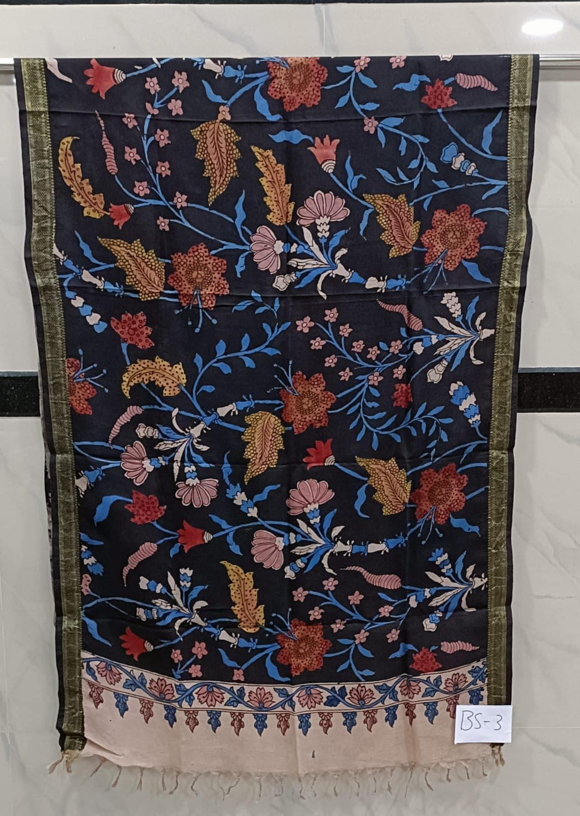 A beautiful kalamkari dupatta featuring intricate hand-painted designs on a lightweight fabric. The designs are primarily inspired by nature, with flowers, birds, and leaves adorning the piece in a mix of bold and muted colors. The borders are lined with delicate patterns and the ends are finished with tassels. The dupatta can be draped over the shoulders or wrapped around the head for a traditional and elegant look."